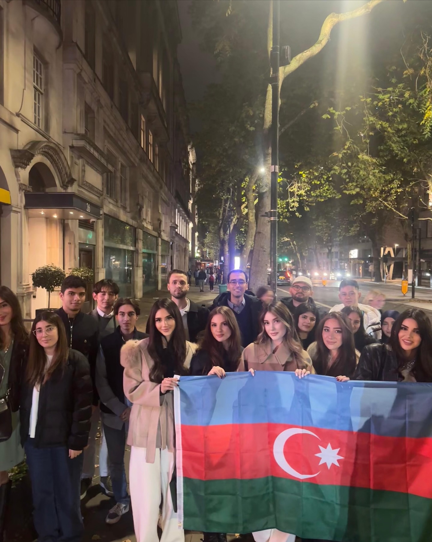 Society members holding the Azerbaijan flag on a London street at night
